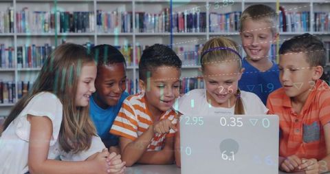 Elementary students collaborating on laptop in school library for digital learning