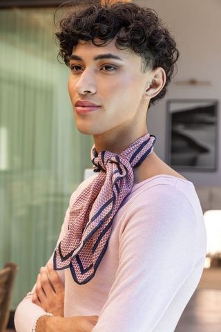 Elegant asian man with silk scarf in minimalist interior
