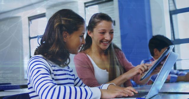 Teenage girls studying together on a tablet in a classroom add a modern and technology-focused element to educational materials. They are happily collaborating, which is perfect for depicting teamwork, digital literacy, and interactive learning in an educational setting. Suitable for educational blogs, e-learning materials, and websites targeting youth education and engagement.