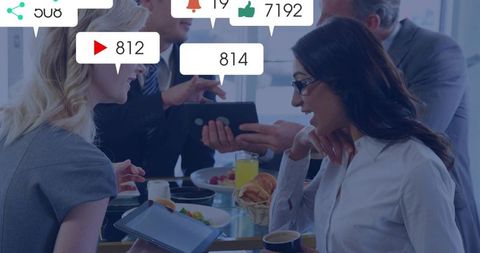 Business team sharing tablet and discussing social media notifications during meeting