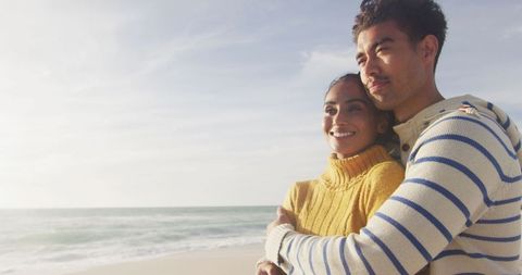 Hispanic Couple Embracing on Serene Beach