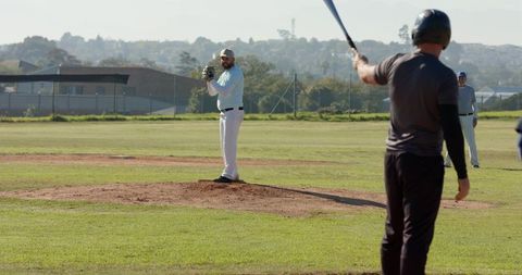 Right-Handed Pitcher Pitching from Mound Facing Batter During Community Baseball Game