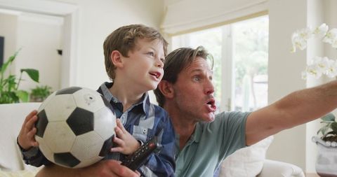 Father and Son Bonding Over Football at Home