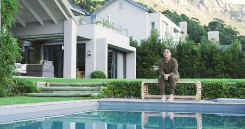 Woman Relaxing by Pool in Modern Backyard Retreat
