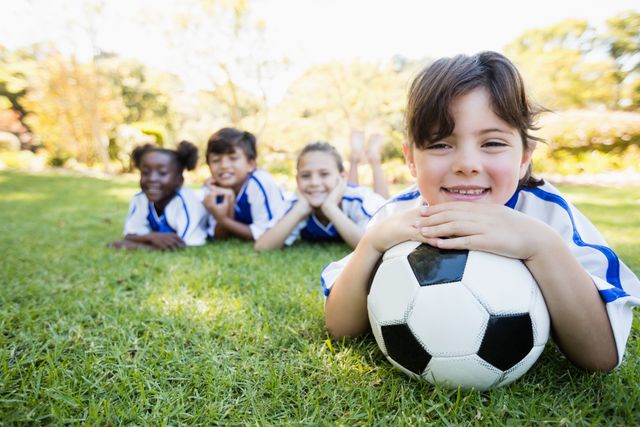 Close up view of girl lying on the floor with her soccer team in park