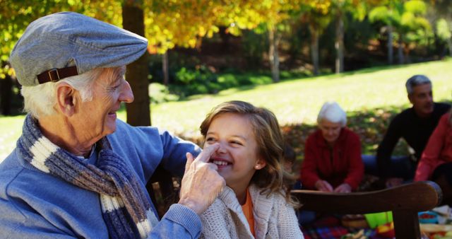 Grandfather and Granddaughter Bonding Outdoors During Picnic in Park - Download Free Stock Images Pikwizard.com