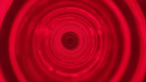 Crimson led tunnel drawing eye into concentric light rings and deep aperture