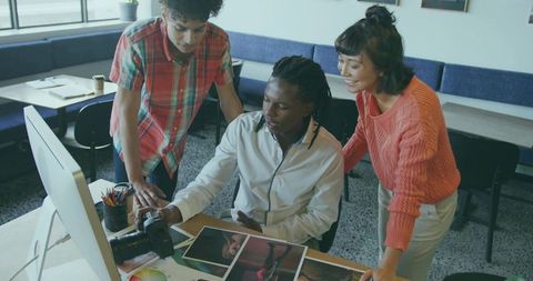 Creative team collaborates on photography project in modern office