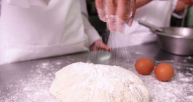 Baker's hands sprinkling flour on dough in kitchen - Download Free Stock Images Pikwizard.com