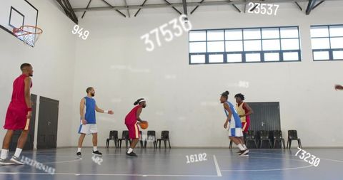 Dribbling player preparing drive on indoor basketball court with digital stats overlay