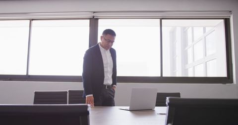 Businessman Engaging With Laptop in Modern Office Environment