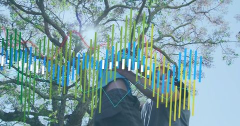 Man lifting boy beneath sunlit tree with colorful data graph overlay for family wellness