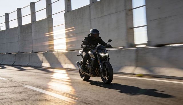 Riding naked motorcycle through urban overpass at sunset with dramatic lensflare