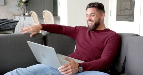 Smiling Bearded Man Using Laptop in Modern Living Room Environment
