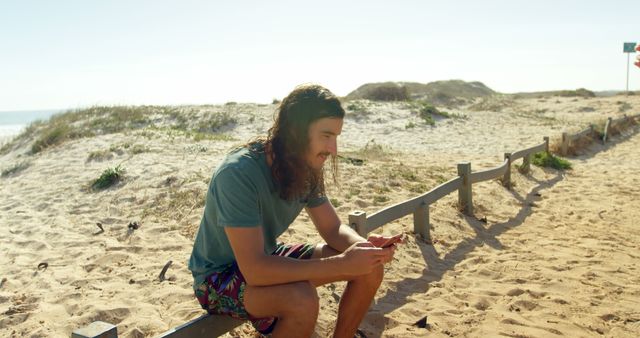 Young Man Relaxing on Beach Dune Using Smartphone - Download Free Stock Images Pikwizard.com