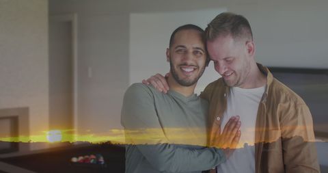 Romantic and diverse male couple embracing at sunset