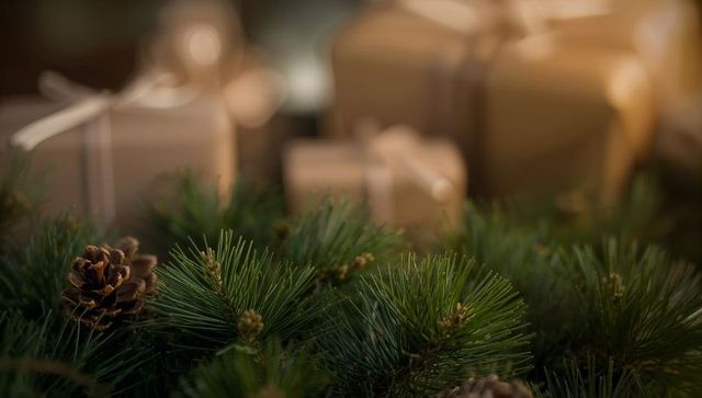 Rustic holiday pine garland featuring kraft-wrapped gifts and warm glowing bokeh lights