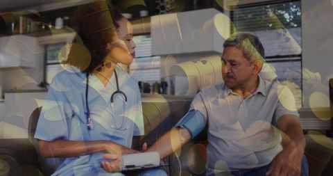 Home healthcare nurse measuring blood pressure for elderly man