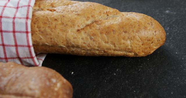 Fresh French Baguette on Dark Surface with Red and White Checkered Cloth - Download Free Stock Images Pikwizard.com