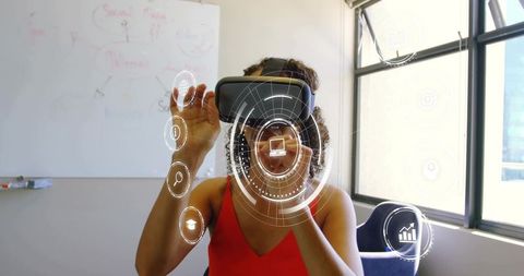Woman manipulating augmented reality interface with vr headset in modern office