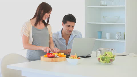 Happy Couple in Modern Kitchen Using Laptop