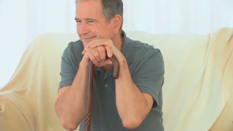 Senior Man Relaxing at Home with Walking Cane