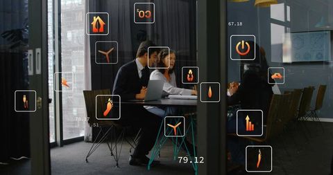 Collaborating business team in glass boardroom showing sustainability icons and analytics