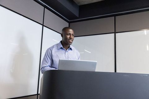 African american man speaking at podium with laptop in conference room