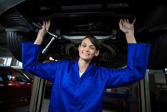 Female mechanic servicing a car in repair garage