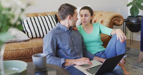 Couple Sitting on Living Room Floor Discussing Bills