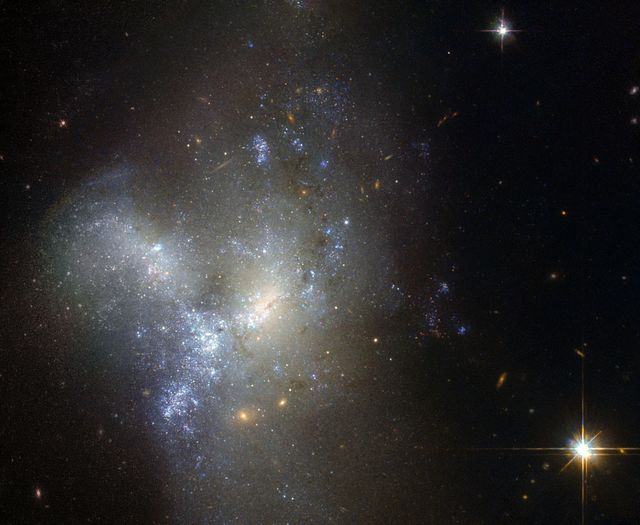 This image, taken by the NASA/ESA Hubble Space Telescope, shows a peculiar galaxy known as NGC 1487, lying about 30 million light-years away in the southern constellation of Eridanus.  Rather than viewing it as a celestial object, it is actually better to think of this as an event. Here, we are witnessing two or more galaxies in the act of merging together to form a single new galaxy. Each galaxy has lost almost all traces of its original appearance, as stars and gas have been thrown by gravity in an elaborate cosmic whirl.  Unless one is very much bigger than the other, galaxies are always disrupted by the violence of the merging process. As a result, it is very difficult to determine precisely what the original galaxies looked like and, indeed, how many of them there were. In this case, it is possible that we are seeing the merger of several dwarf galaxies that were previously clumped together in a small group.  Although older yellow and red stars can be seen in the outer regions of the new galaxy, its appearance is dominated by large areas of bright blue stars, illuminating the patches of gas that gave them life. This burst of star formation may well have been triggered by the merger.  Image credit: ESA/Hubble &amp; NASA, Acknowledgement: Judy Schmidt  <b><a href="http://www.nasa.gov/audience/formedia/features/MP_Photo_Guidelines.html" rel="nofollow">NASA image use policy.</a></b>  <b><a href="http://www.nasa.gov/centers/goddard/home/index.html" rel="nofollow">NASA Goddard Space Flight Center</a></b> enables NASA’s mission through four scientific endeavors: Earth Science, Heliophysics, Solar System Exploration, and Astrophysics. Goddard plays a leading role in NASA’s accomplishments by contributing compelling scientific knowledge to advance the Agency’s mission.  <b>Follow us on <a href="http://twitter.com/NASAGoddardPix" rel="nofollow">Twitter</a></b>  <b>Like us on <a href="http://www.facebook.com/pages/Greenbelt-MD/NASA-Goddard/395013845897?ref=tsd" rel="nofollow">Facebook</a></b>  <b>Find us on <a href="http://instagrid.me/nasagoddard/?vm=grid" rel="nofollow">Instagram</a></b>  