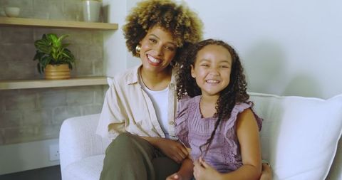 Happy mother and daughter bonding on cozy white couch