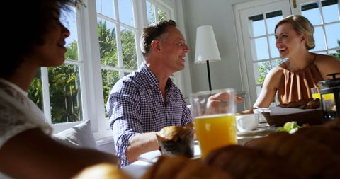 Diverse Adults Enjoying Breakfast Together in Sunlit Room