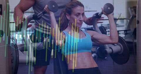 Woman doing seated shoulder press while trainer spotting with fitness analytics overlay