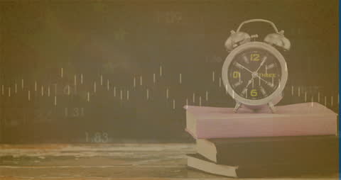 Analog Clock on Books with Financial Charts Background