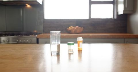 Minimalist kitchen counter with medication and glass of water