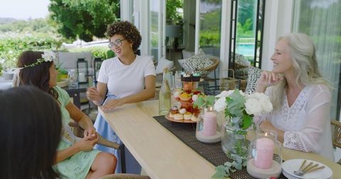 Women Socializing at Elegant Outdoor Gathering with Desserts and Drinks