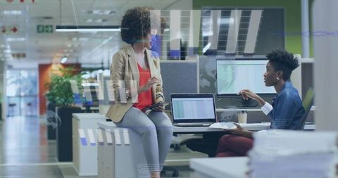Women collaborating over dashboards and analytics on laptop and tablet in modern office