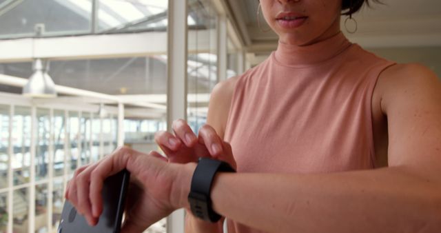 Woman Using Fitness Tracker Checking Notifications in Modern Office - Download Free Stock Images Pikwizard.com