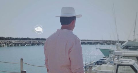 Man in straw hat enjoying relaxing coastal view at marina