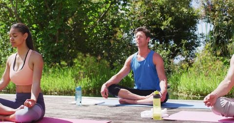 Group Meditating in Sunshine, Practicing Yoga in Tranquil Park
