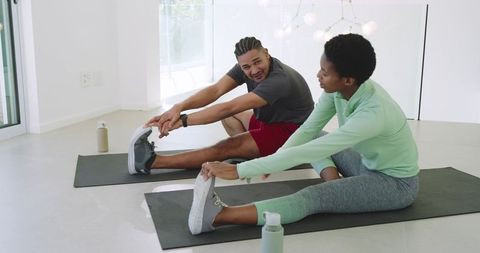Diverse Workout Partners Stretching in Home Gym