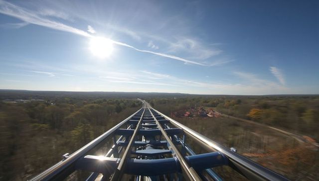 Thrilling roller coaster view with sunlit forest