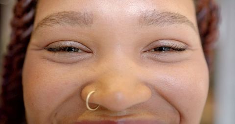 Close-Up Smiling Woman Displaying Joy and Facial Jewelry