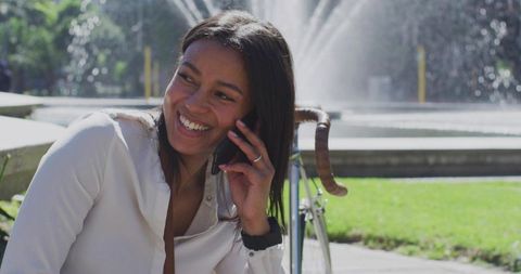 Woman Relaxing and Talking by Fountain with Bicycle