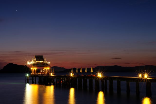 Pier with Illuminated Pavilion at Dusk Over Serene Lake - Download Free Stock Photos Pikwizard.com
