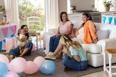 Diverse Group of Women Enjoying Time with Infant in Cozy Living Room