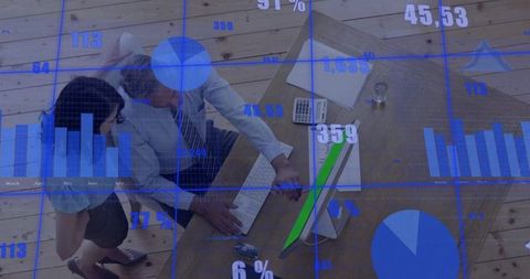 Overhead team analyzing data dashboards at workstation for collaboration and analytics