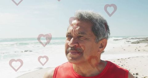 Senior man in red enjoying beach walk with heart overlays