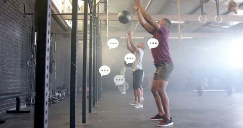 Fit Athletes Slamming Medicine Balls in Gym Training Session